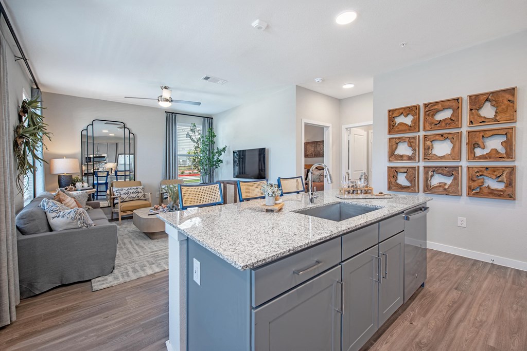 a kitchen with an island and a living room with a tv