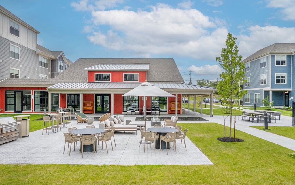 a patio with tables and chairs in front of a building