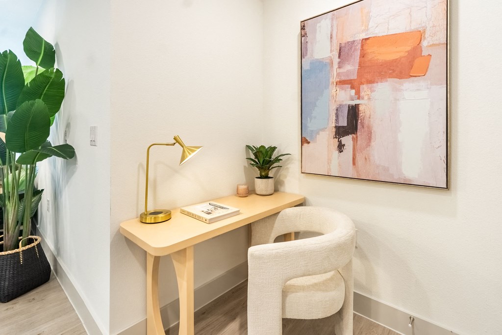 a desk with a chair and a large painting on the wall