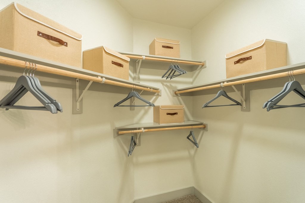 a storage room with boxes on shelves and hangers on the wall