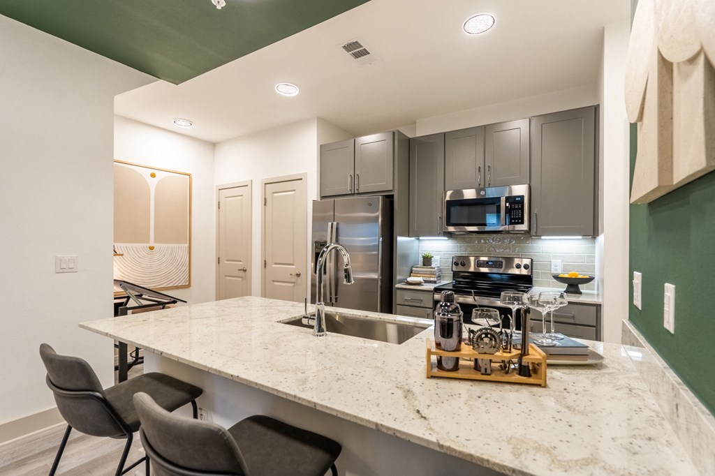a kitchen with a marble counter top and stainless steel appliances