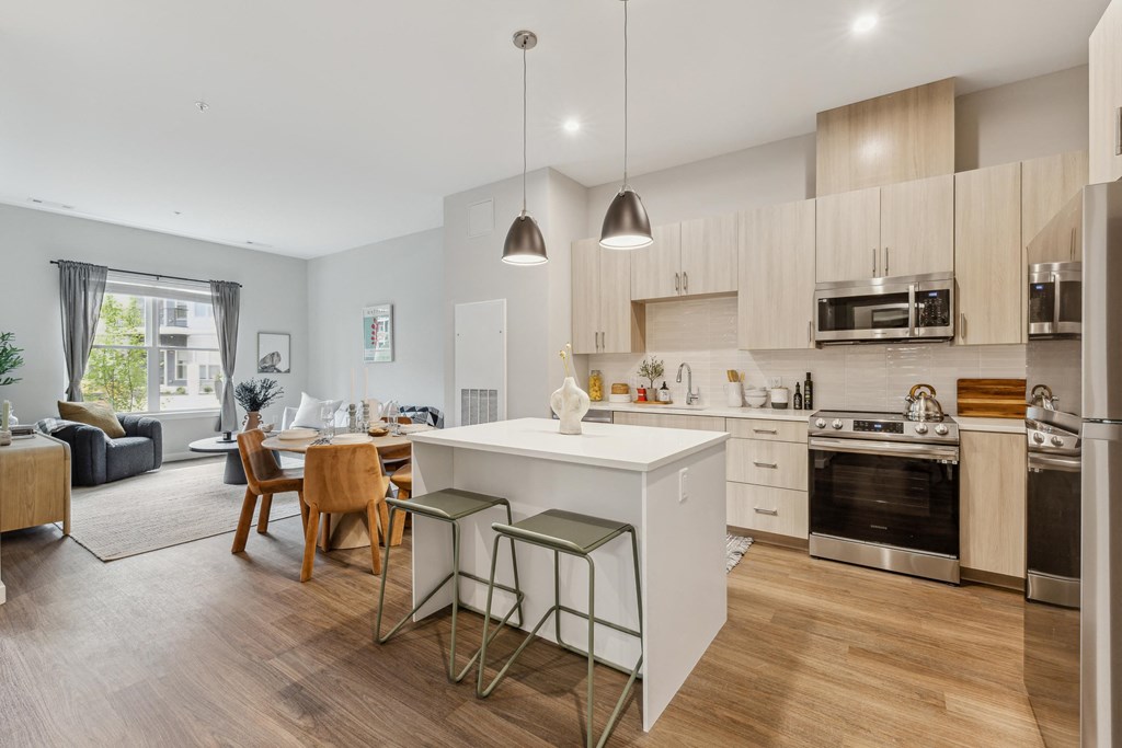 a kitchen with a white island and a dining room