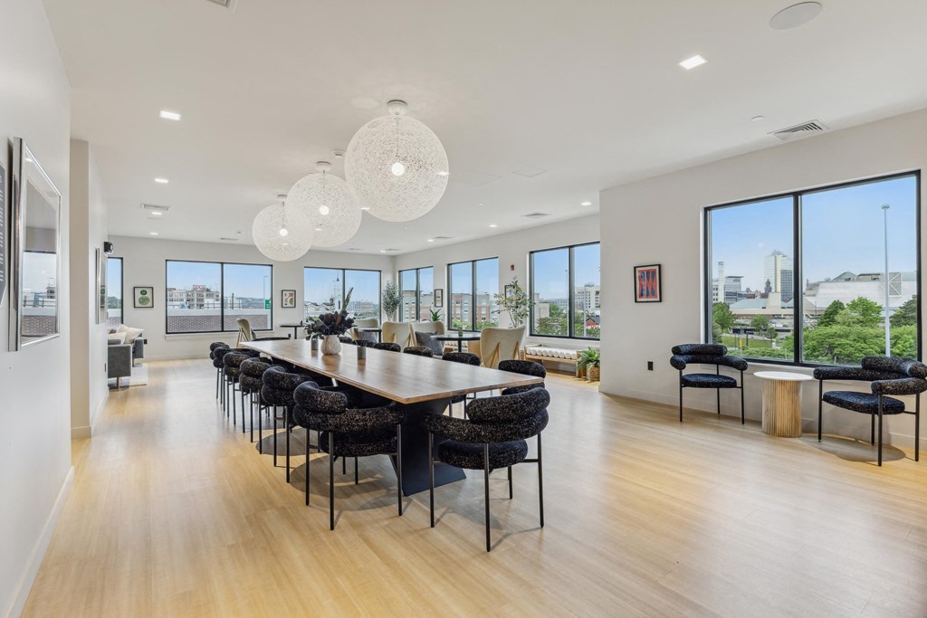 a dining room with a long table and chairs and large windows