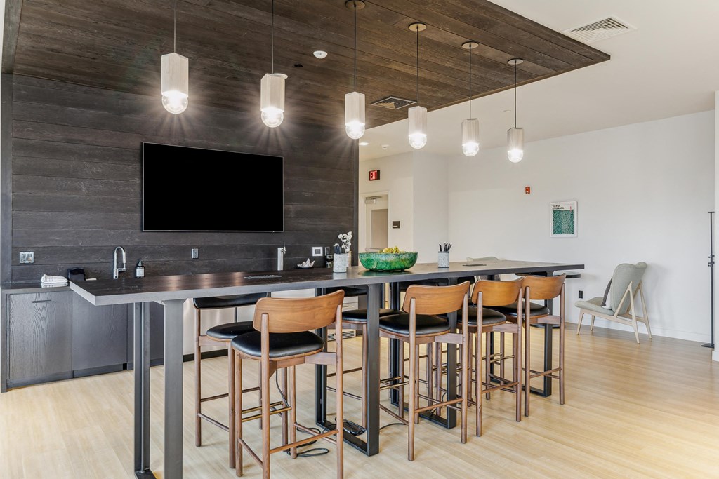 a kitchen with a large island with stools and a table with chairs