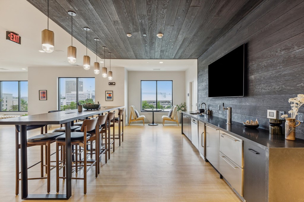 a large kitchen with a bar and chairs and a tv