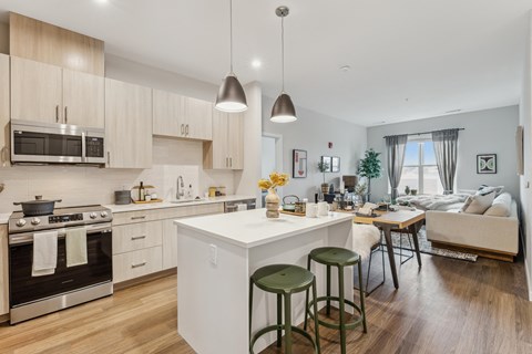 a kitchen and living room with a white island and stools