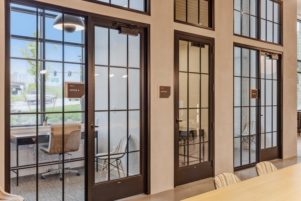 a conference room with glass doors and a table and chairs