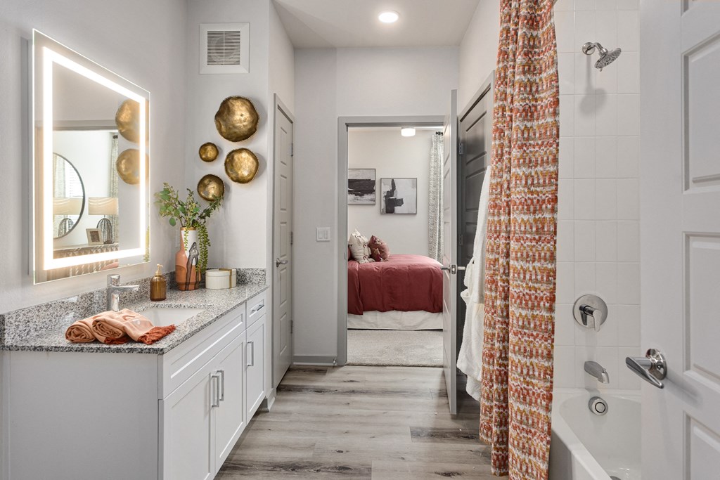 a bathroom with a shower and a sink and a bed