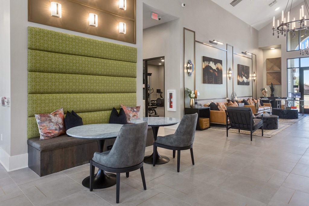 a communal area with tables and chairs in the lobby of a building