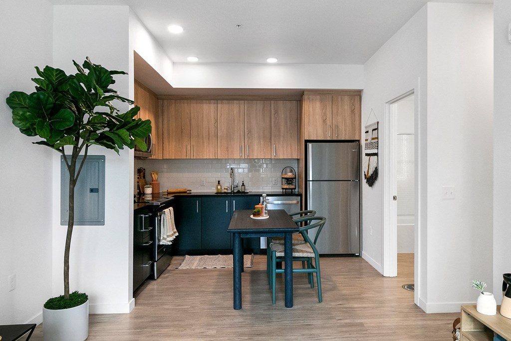 a kitchen and dining area with a table and chairs and a refrigerator