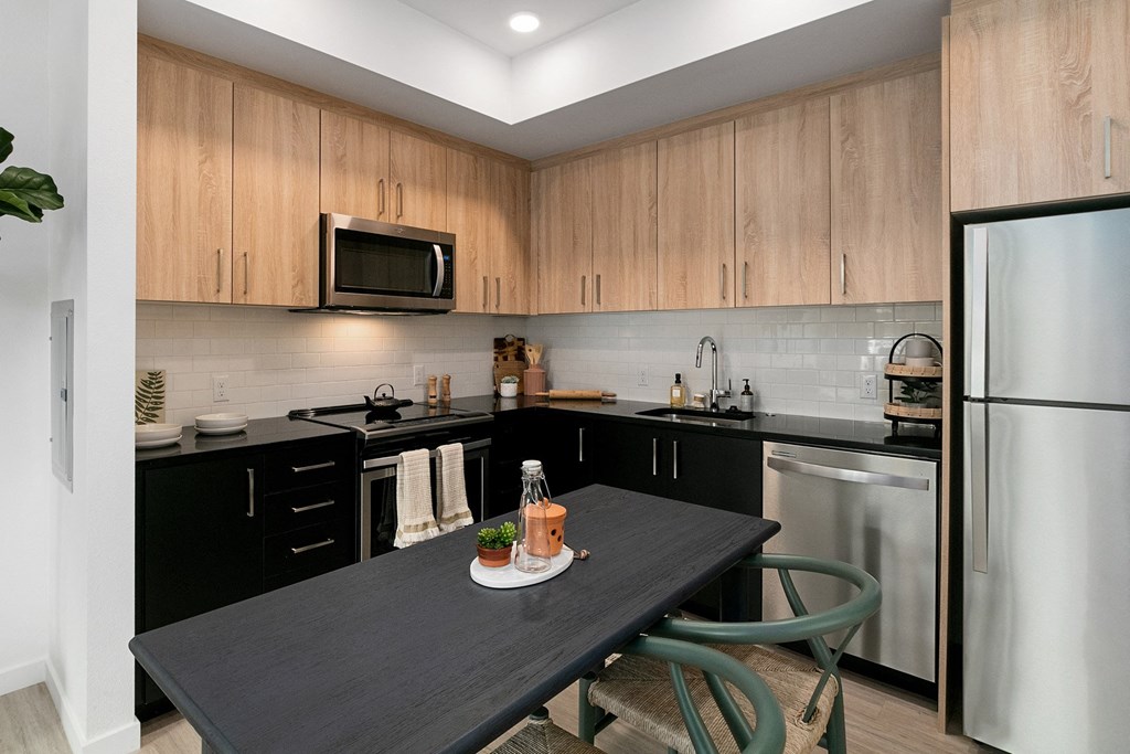 a kitchen with black counters and a black dining table