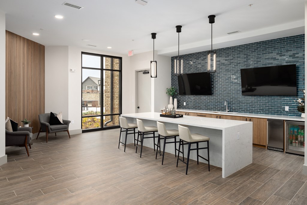 an open kitchen with a large island with bar chairs and a television  at Alta Northerly, Cumming, Georgia