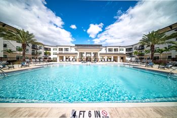 a large swimming pool with apartments in the background