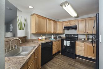 the preserve at ballantyne commons apartment kitchen with black appliances and wooden cabinets