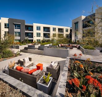 an outdoor patio with furniture in front of an apartment building