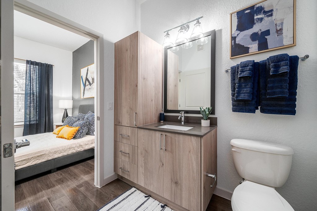 Bathroom with a Toilet and a Vanity with a Mirror at AVILA Apartments, Florida
