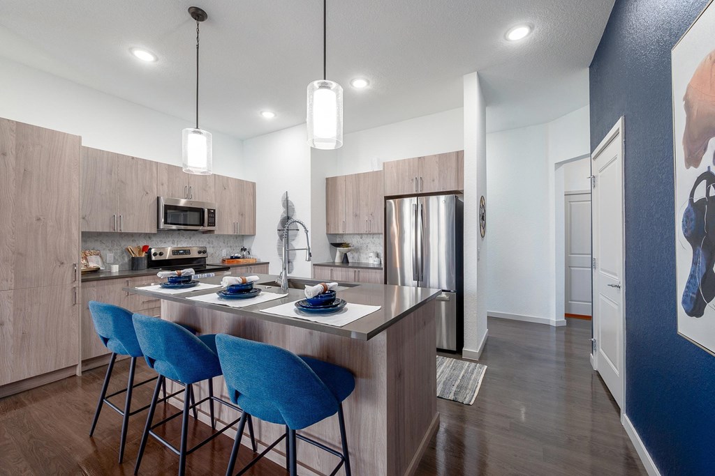 Open Kitchen with Large Island with Blue Stools at AVILA Apartments, Oviedo Florida