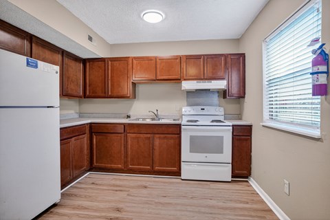 A kitchen with wooden cabinets and a white refrigerator.
