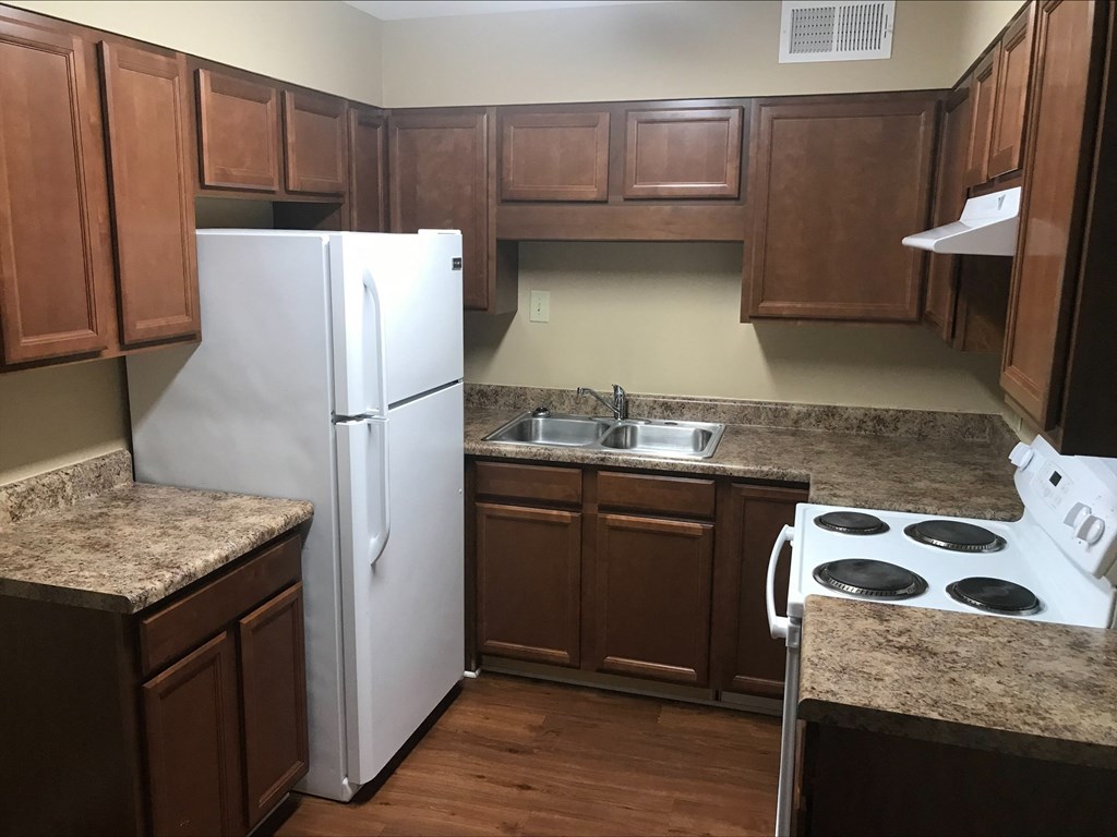 a kitchen with wooden cabinets and a white refrigerator