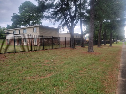 a house with a yard and a fence in front of it