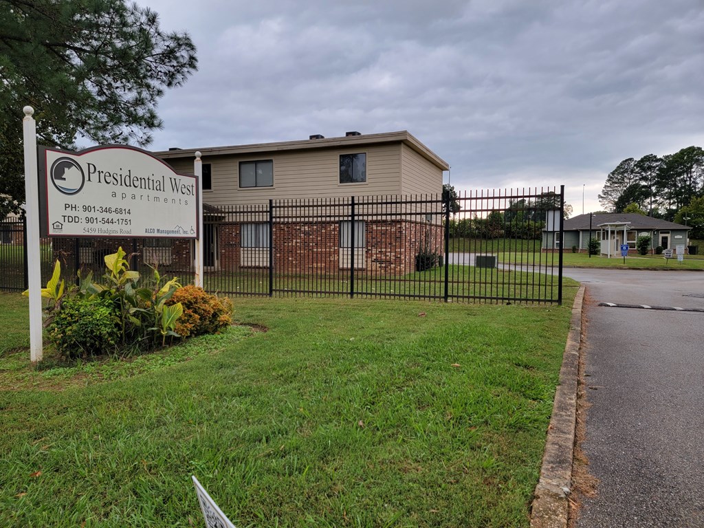 a building with a fence and a sign in front of it