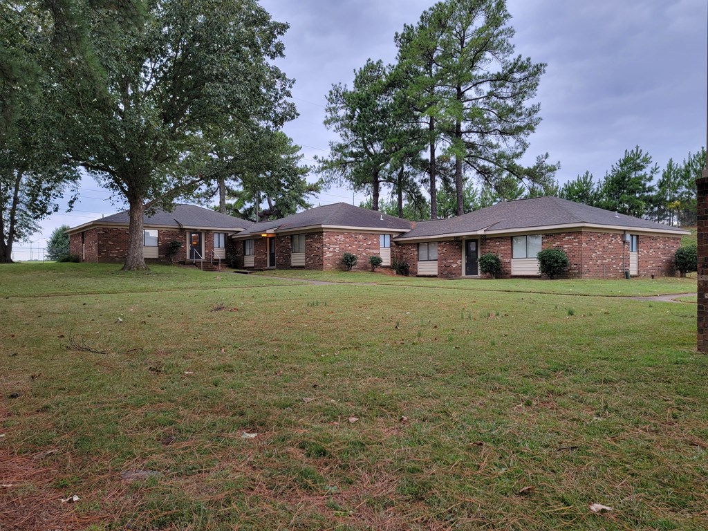 a large brick house with trees in front of it