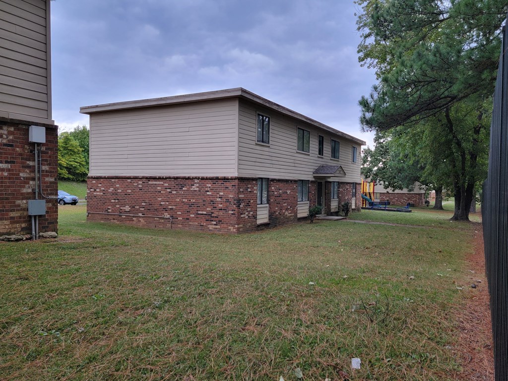a brick and with a yard and trees