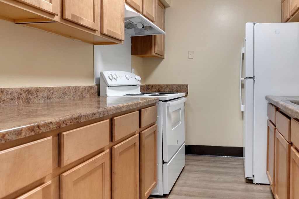 A kitchen with wooden cabinets and a white dishwasher.