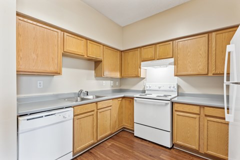 A kitchen with wooden cabinets and white appliances.