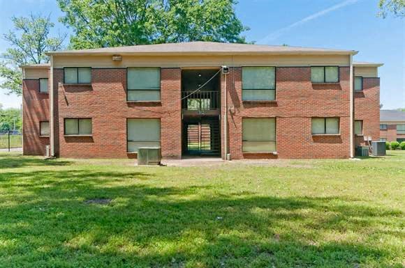 a brick building with green grass in front of it