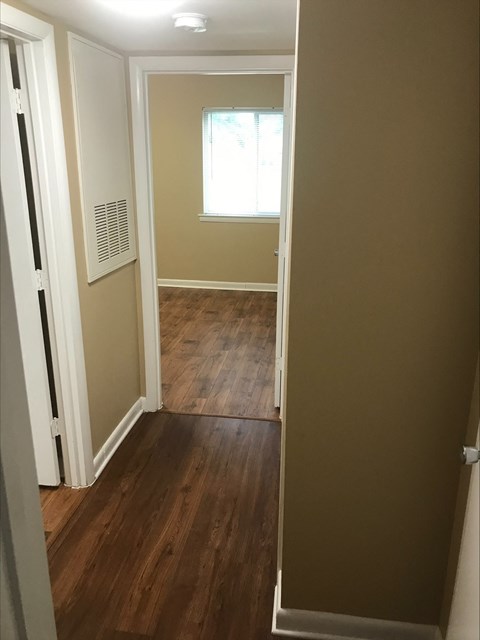 a hallway with a hard wood floor and a window
