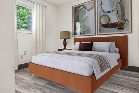 A bedroom with a large bed and two paintings on the wall.
