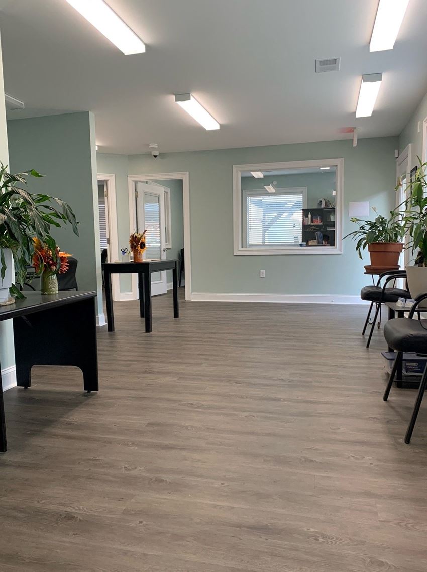 a hallway with tables and chairs and a mirror on the wall