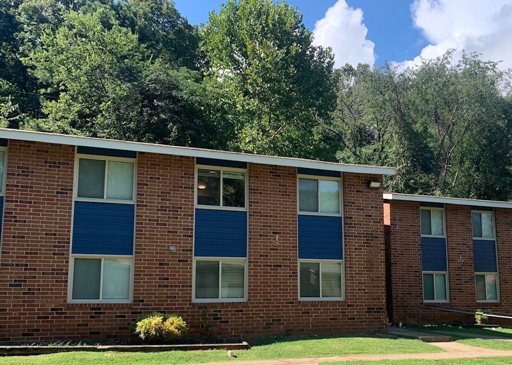 a brick building with blue shutters on the windows