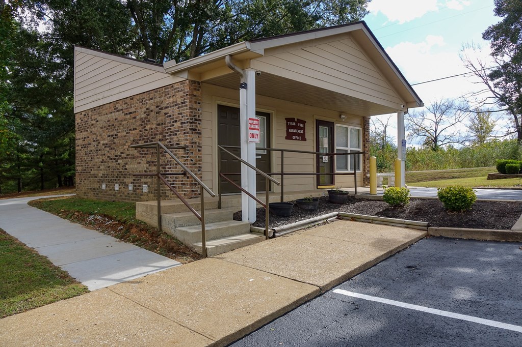 a small brown building with a porch and stairs