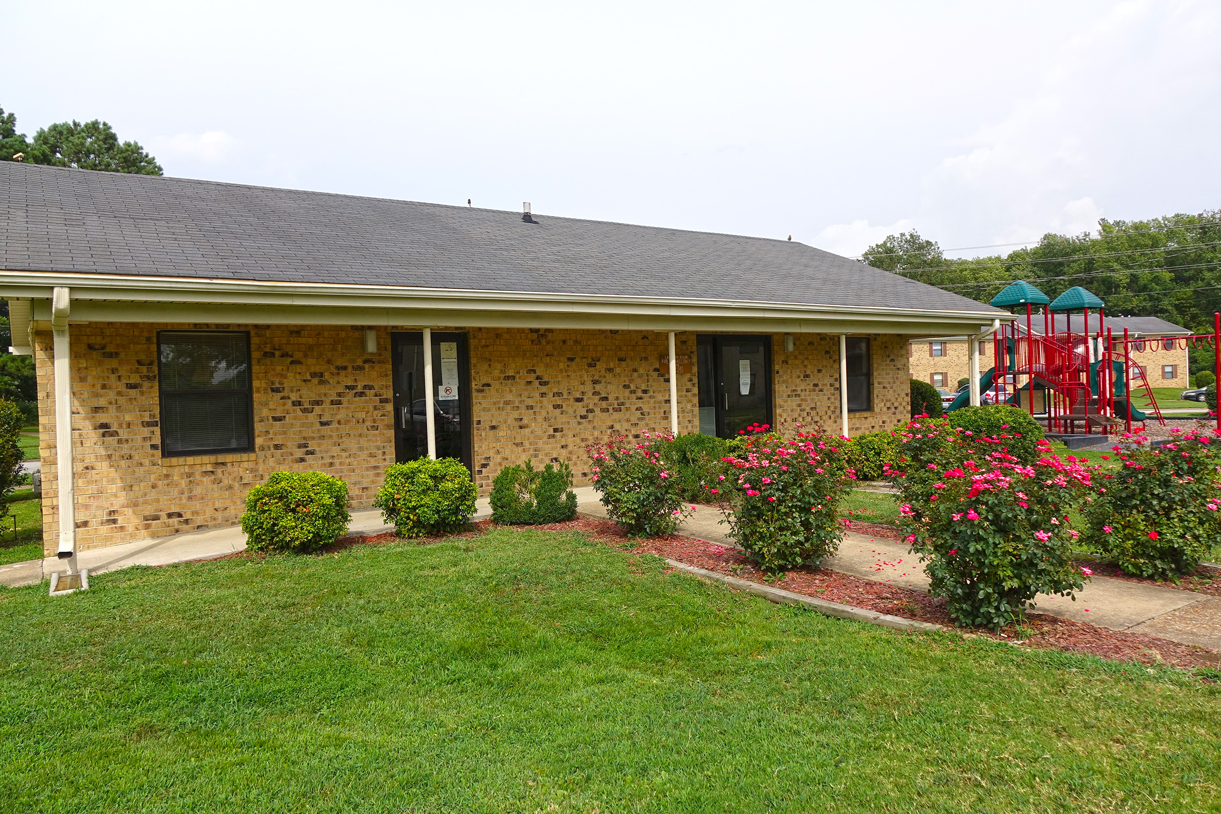 a house with a yard and flowers in front of it