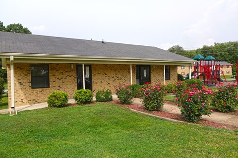 a house with a yard and flowers in front of it