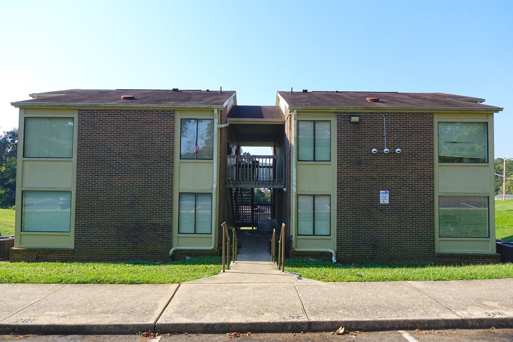 an image of a two story brick apartment building with a brown roof.