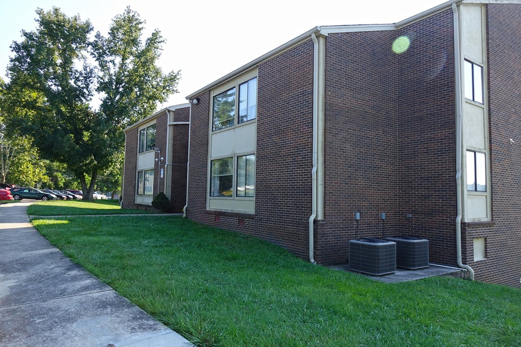 a brick building with a grassy yard in front of it