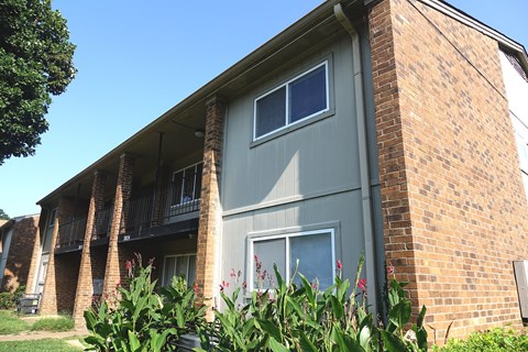 A grey apartment building with a brick chimney.