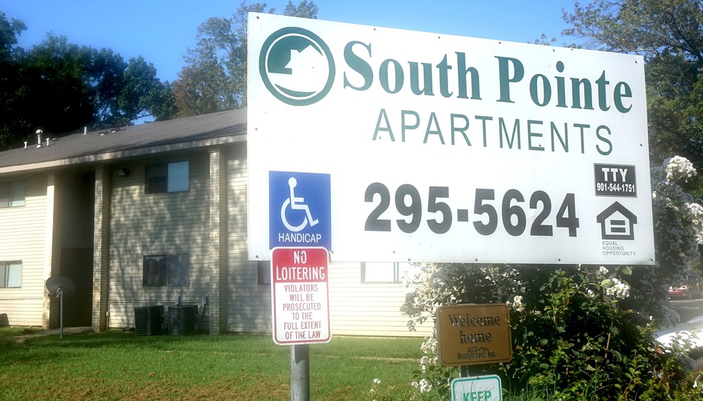 a sign for south point apartments in front of a house