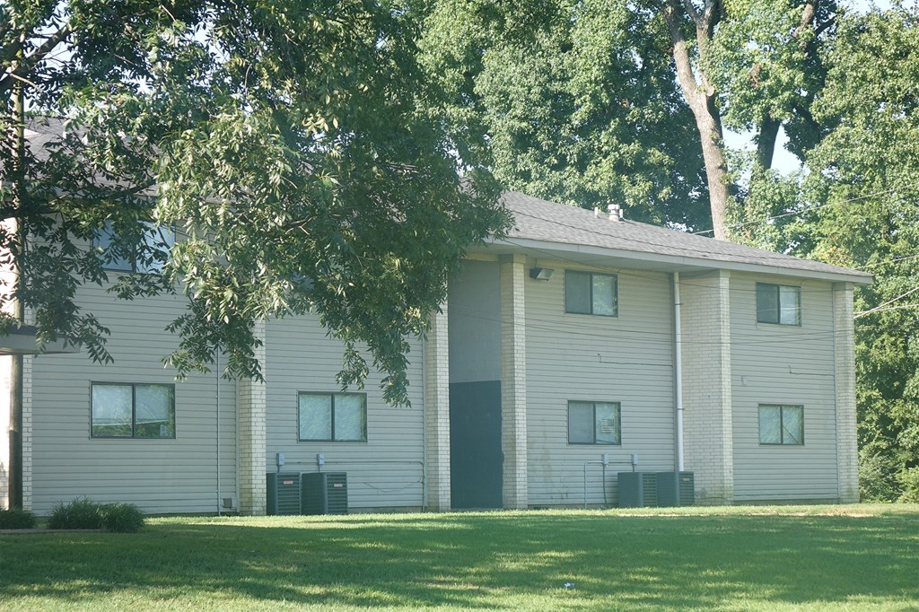 a white building with a tree in front of it