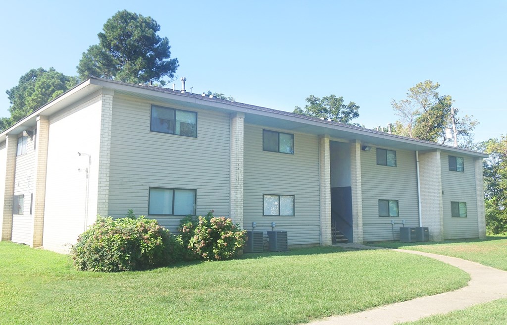 an apartment building with a sidewalk in front of it