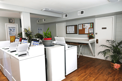 an office with four white filing cabinets and a desk with a bulletin board