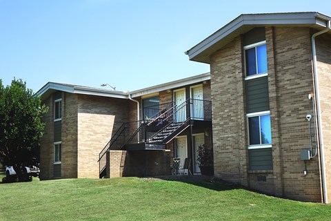 an exterior view of a brick apartment building with a staircase