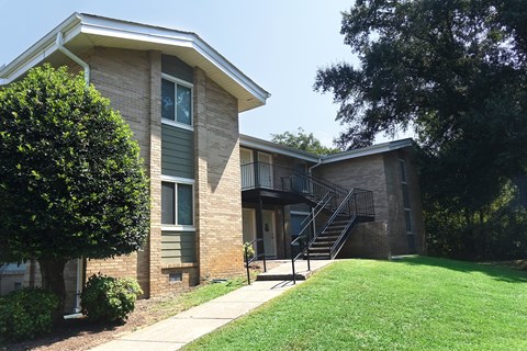 an exterior view of a building with a yard and stairs