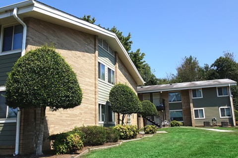 an exterior view of a building with a lawn and trees