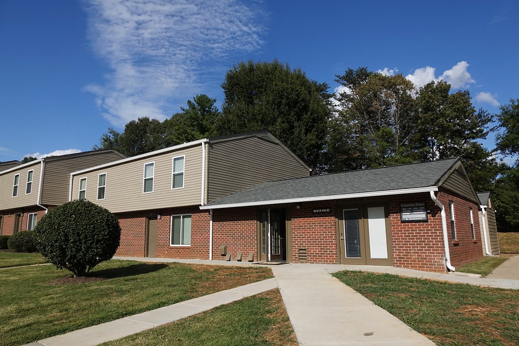 an exterior view of a brick building with a sidewalk