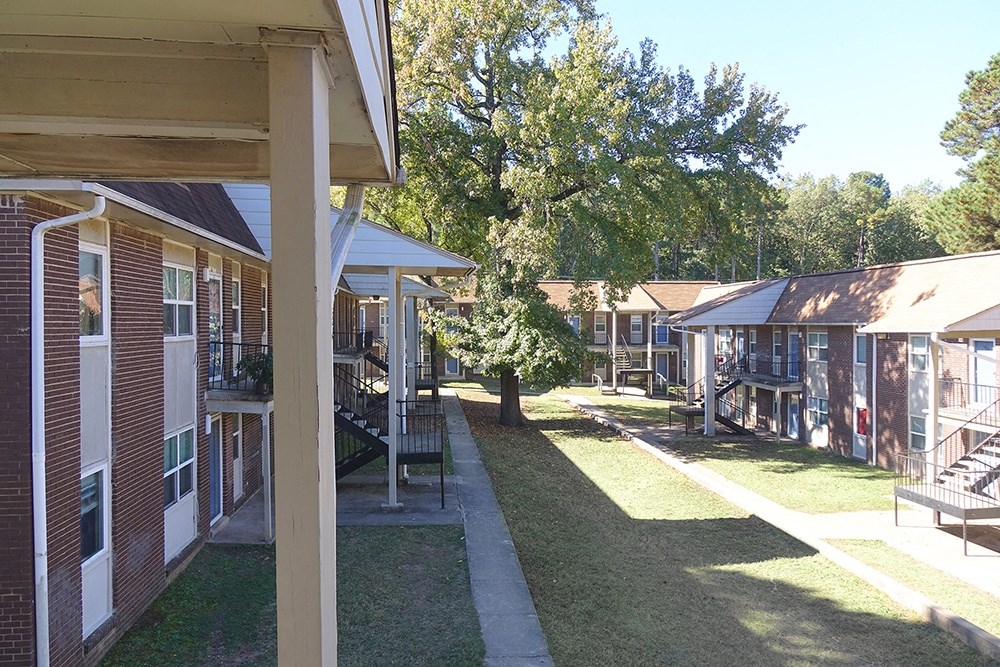 a row of houses with a lawn and trees