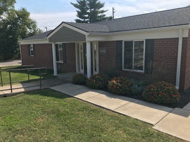 a brick house with a sidewalk in front of it